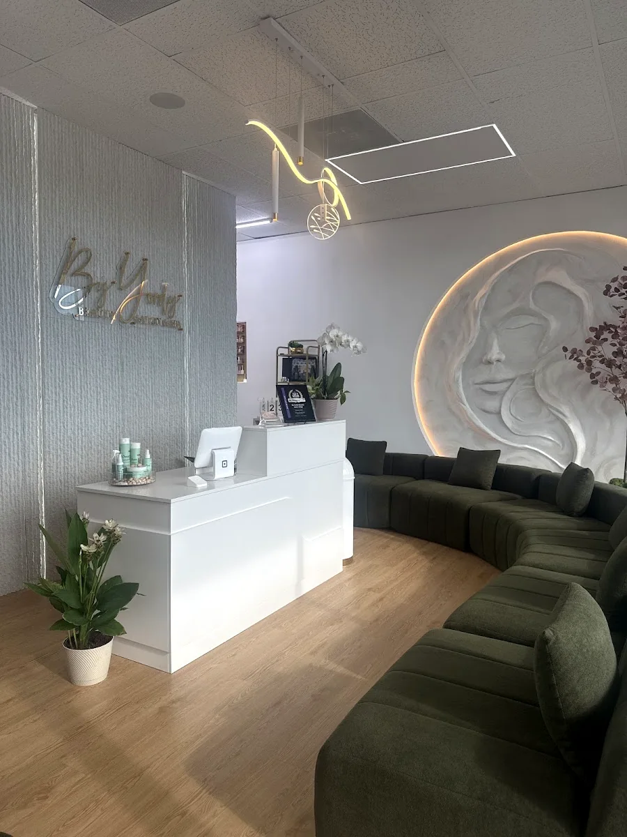 Reception at By Yordy Beauty Salon & Spa: gold wall lettering and olive velvet lounge